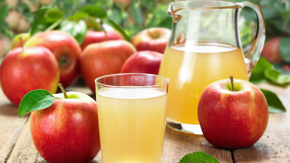 Pfanner Getränke Apfelsaft naturtrüb Naturtrüber Apfelsaft im Glas mit Äpfeln dekoriert