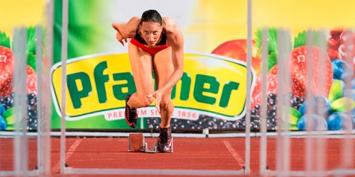 Pfanner Getränke Sport Hürdenläuferin vor Pfanner-Banner